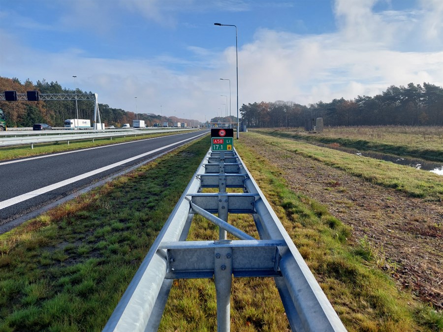 vangrail met hectometerbordje in de berm naast de snelweg